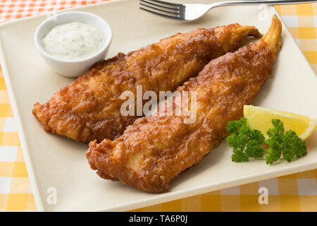 Fritti di filetto di pesce, chiamato lekcurbek in olandese servito con salsa di limone e chiudere fino Foto Stock