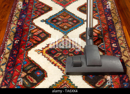 Close-up di un aspirapolvere su un tappeto orientale Foto Stock