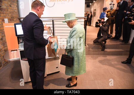 La regina Elisabetta II è illustrato un moderno self service fino a come lei vede una replica di uno degli originali Sainsbury's stores durante una visita a Covent Garden di Londra. La manifestazione ha segnato il centocinquantesimo anniversario della catena di supermercati prima apertura. Foto Stock