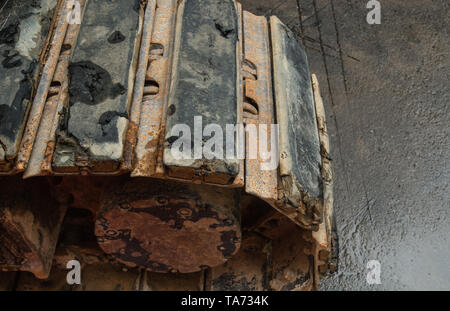 Primo piano di escavatore vie coperte di sporco sul sito in costruzione Foto Stock