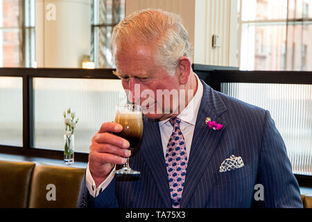 Il Principe di Galles ha un bicchiere di Belfast Black fatta da Whitewater birreria come frequenta un ricevimento presso il Grand Central Hotel ha ospitato dallo Spirito di Belfast per celebrare coloro coinvolti nella fornitura il successo del turismo e artigianale di settori alimentari a Belfast. Foto Stock