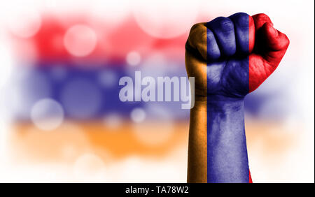 Bandiera dell'Armenia dipinta sul pugno maschio, forza,alimentazione,nozione di conflitto. Su uno sfondo sfocato con un buon posto per il vostro testo. Foto Stock