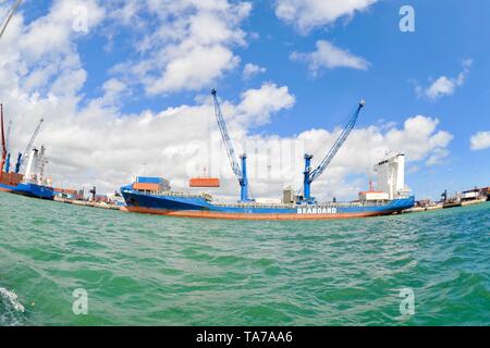 Grande contenitore oceano nave con contenitori essendo sollevata sulla nave con gru nel Porto di Miami e a Miami, Florida, Stati Uniti d'America Foto Stock