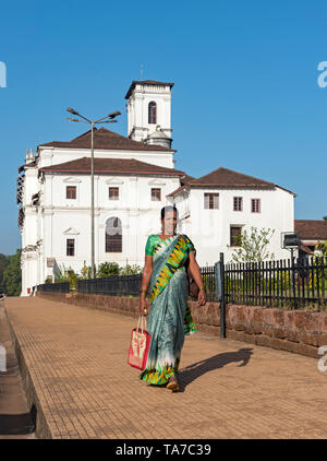 Donna indiana in sari abito al di fuori della chiesa di San Francesco di Assisi, Old Goa, India Foto Stock