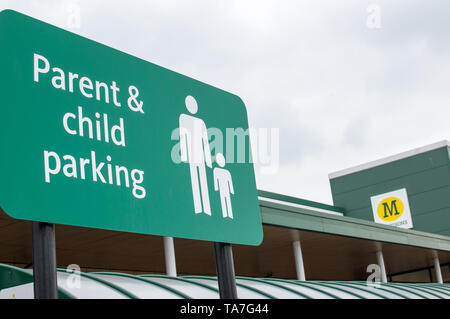 Genitore e bambino parcheggio segno bordo in Morrisons supermercato Foto Stock