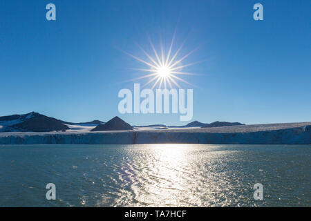 Il sole di mezzanotte sopra il ghiacciaio Sefstroembreen. Ekmanfjord, Svalbard, Norvegia. Foto Stock