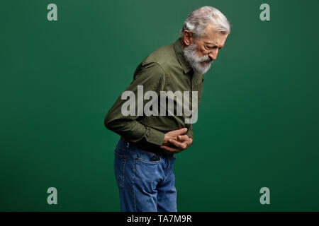 Uomo vecchio con il grigio barba lunga ha problemi di stomaco. infezione, senior l uomo ha cibo nato malattia.intossicazione acuta s. close up vista laterale foto Foto Stock
