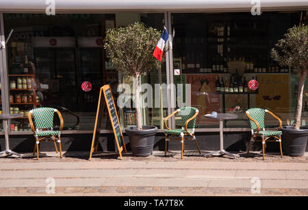 Caffè francese terrazza vola il tri-colori nella parte anteriore del ristorante e il negozio. Al di fuori dell'immagine con sedie e tavoli, billbords e olivi. Copenaghen, De Foto Stock