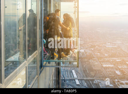 Chicago, Illinois, USA, ottobre 2016: un gruppo di turisti che si godono il panorama visibile dal vetro trasparente battute sul pavimento 103 del Foto Stock