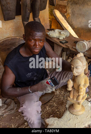 Maestro intagliatore di legno facendo una statua Senufo, Poro regione, Korhogo, Costa d'Avorio Foto Stock