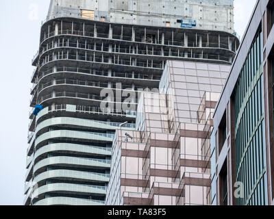 La gru e la costruzione di dispositivo su un sito di costruzione di un grattacielo nel centro cittadino di Toronto, circondato da altre alte torri e condomini nonché olde Foto Stock