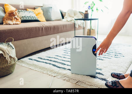 La donna diventa deumidificatore a utilizzando il touch panel a casa. Phon moderno dispositivo per la depurazione dell'aria. Close up Foto Stock