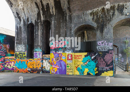 La street art e graffiti dipinti sui muri delle arcate ferroviarie nel distretto creativo di Digbeth, Birmingham, Regno Unito Foto Stock