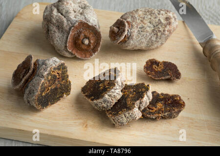 Kaki secchi frutta e le fette su un tagliere Foto Stock
