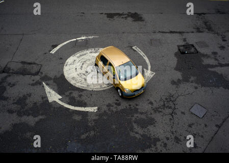 Vista aerea di un dipinto di freccia rotonda con una sola vettura andando in giro. Potrebbe essere usato come una analogia o nozione come perso o andando in cerchi. Foto Stock