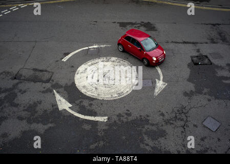 Vista aerea di un dipinto di freccia rotonda con una sola vettura andando in giro. Potrebbe essere usato come una analogia o nozione come perso o andando in cerchi. Foto Stock