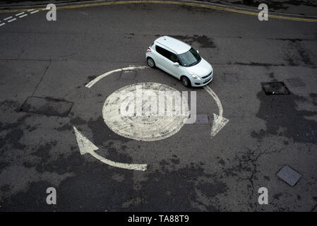 Vista aerea di un dipinto di freccia rotonda con una sola vettura andando in giro. Potrebbe essere usato come una analogia o nozione come perso o andando in cerchi. Foto Stock