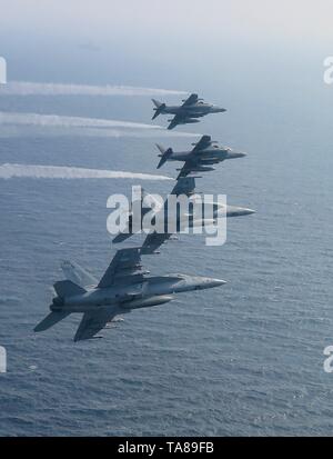 Stati Uniti Navy F/A-18E Super Hornet fighter aircraft dal Jolly Rogers di Strike Fighter Squadron 103 patrol A FIANCO DEGLI STATI UNITI Marine AV-8B Harrier getti durante le operazioni 18 maggio 2019 nel Mare Arabico. Il joint strike gruppo è parte delle forze aggiuntive essendo inviato in Medio Oriente per contrastare ciò che Trump gestione chiamate chiare indicazioni di minacce dall'Iran. Foto Stock