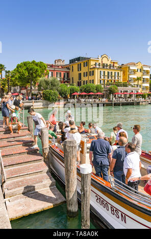 SIRMIONE SUL LAGO DI GARDA, Italia - Settembre 2018: guida del tour con una bandiera che conducono il visitatore arouns le strade di Sirmione sul Lago di Garda. Foto Stock