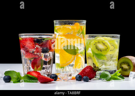 Vari frullati colorati o di succhi di frutta in bottiglie e ingredienti sul buio. Una sana dieta vegana detox alimenti puliti concetto, vista dall'alto. Foto Stock