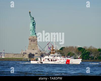 US Coast Guard Sentinel-classe vela di taglio di fronte alla statua della Libertà, flotta settimana, New York, NY, STATI UNITI D'AMERICA Foto Stock