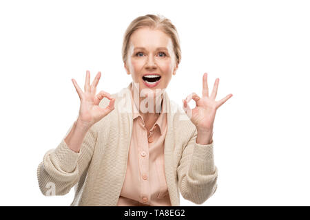 Excited donna di mezza età che mostra segni ok isolato su bianco Foto Stock