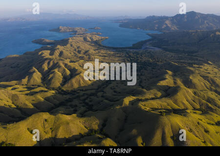 Visto dall'occhio di un uccello, il blu Oceano Pacifico circonda il robusto isola di Komodo in Indonesia. Questa area tropicale è nota per la sua diversità. Foto Stock