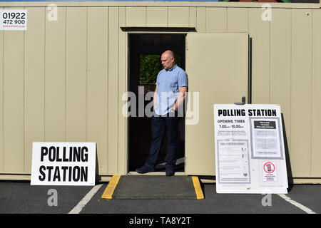 Un ufficiale delle elezioni attende gli elettori in corrispondenza di una stazione di polling alloggiato in una cabina temporanea su un consiglio del parco auto in Sydney Road, Cradley Heath, West Midlands, come testa gli elettori a votare per il Parlamento europeo elezioni. Foto Stock