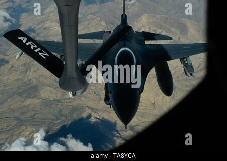 Un U.S. Air Force F-16 Fighting Falcon si prepara a collegare con una KC-135 Stratotanker assegnato al 340 Expeditionary Air Refuelling Squadron fuori Kandahar Airfield, Afghanistan, durante un rifornimento di antenna missione sopra una località segreta Maggio 14, 2019. La F-16 riempie un ruolo critico di abilitazione di sicurezza locale e chiudere il supporto aereo per le forze della coalizione sul terreno. (U.S. Air Force photo by Staff Sgt. Chris Drzazgowski) Foto Stock