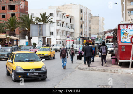 Paesaggio urbano con auto e residenti di una piccola città. Tunisia, Africa Foto Stock