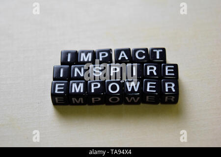 Impatto - Ispirare - Empower su blocchi di legno. Business e concetto di ispirazione Foto Stock