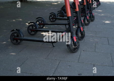 Eco moderna città elettrico scooter per noleggiare fuori sul marciapiede. Turismo alternativo, trasporto intorno alla città, bici Servizio di sostituzione. E- Foto Stock
