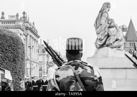 Nero soldato etnia alla cerimonia per gli alleati occidentali la Seconda Guerra Mondiale la vittoria armistizio in Europa pagando tributo davanti a un monumento aux morts de Strasbourg immagine monocromatica Foto Stock