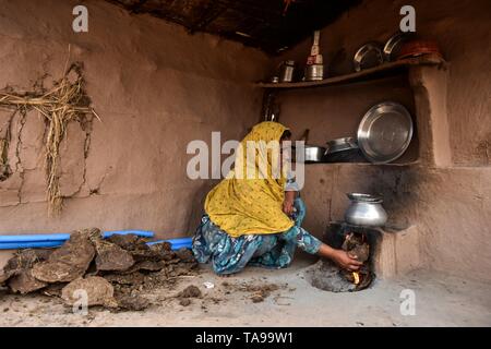 Un indiano nomad donna vede la cottura su un combustibile efficiente stufa in Patiala distretto del Punjab (India). Foto Stock