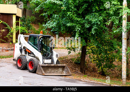Wheel loader or bulldozer with a bucket in the city park. Foto Stock