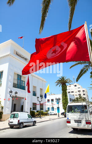 SOUSSE, TUNISIA AFRICA-CIRCA maggio, 2012: tunisina bandiera nazionale onde contro l'edificio amministrativo nella città di Sousse. Tutti gli edifici del governo deve ha Foto Stock