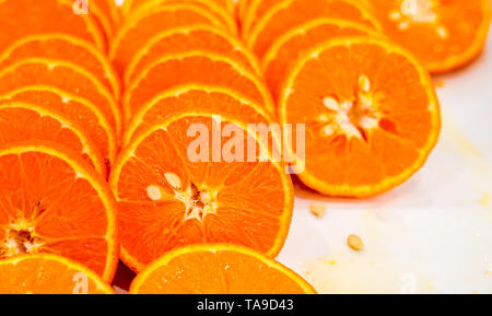 Fresh cut arancione sullo sfondo di frutta, molti pezzi di arance, macro close up foto di cibo sano, vista dall'alto Foto Stock
