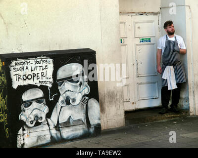 Un cuoco prende una pausa ciggie fuori in Brighton Foto Stock