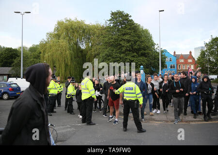 Salford, Regno Unito. 22 Maggio, 2019. La polizia tenere indietro arrabbiato Tommy Robinson sostenitori e escort anti razzismo gli attivisti al di fuori della zona dopo che essi avevano tenuto un contatore protesta. Missili di pietre e sassi sono stati gettati e uno anti razzista è stato colpito sotto l'occhio. La polizia sequestrato un autobus che passa a prendere il anti razzisti lontano dalla zona per la propria sicurezza. Mocha Parade, inferiore Broughton, Salford. Credito: Barbara Cook/Alamy Live News Foto Stock