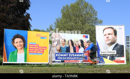 Il 30 aprile 2019, Assia, Frankfurt/Main: ad est di Francoforte, un ciclista aziona passato elezione dei poster di FDP (l-r), SPD e CDU per le elezioni europee. L'elezione diretta del Parlamento europeo avrà luogo in Germania il 26 maggio 2019. 4.7 milioni di Hesse sono chiamati a votare. Foto: Arne Dedert/dpa Foto Stock