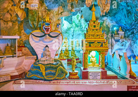 PINDAYA, MYANMAR - 19 febbraio 2018: scenic statue di Buddha con Naga-Raja serpente e la pagoda ornati, situato in bianco la grotta di stalattiti di abbassare l Foto Stock