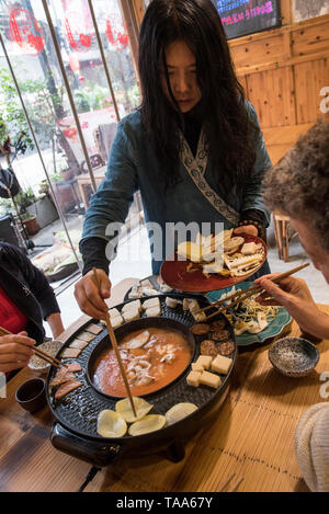 Hot Pot Restaurant a Chengdu Sichuan, in Cina. Il cibo viene cotto in un brodo a tavola Foto Stock