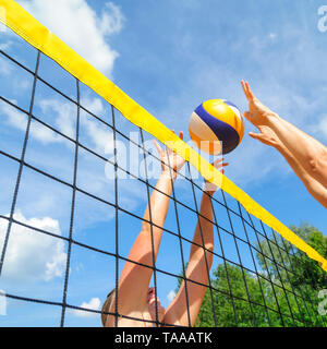 Gioco competitivo sul campo da pallavolo di spiaggia al netto Foto Stock