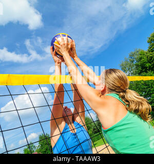 Gioco competitivo sul campo da pallavolo di spiaggia al netto Foto Stock