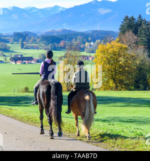 Rilassate le donne facendo un tour con i propri cavalli in falltime Foto Stock