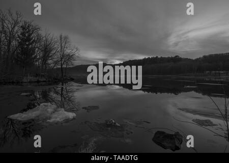 Bianco e nero ampio angolo di visualizzazione orizzontale del vasto St. Croix fiume su un gelido inverno tramonto / inizio serata - separazione del fiume Wisconsin e Minne Foto Stock