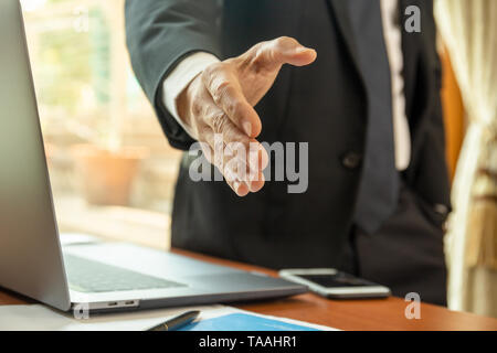 Imprenditore e permanente di raggiungere fuori mano per scuotimento. Foto Stock