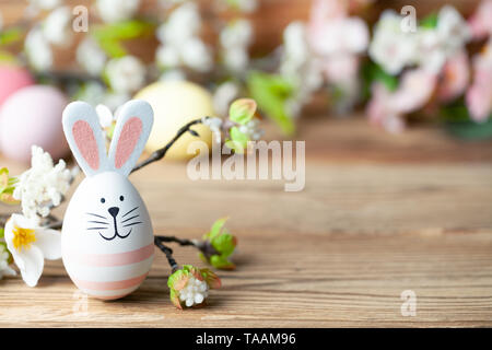 Felice Pasqua lo sfondo con il coniglietto di pasqua, uova di pasqua e fiori Foto Stock