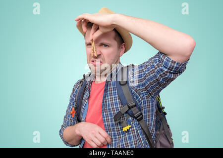 Giovane uomo in estate con cappello di clothespin sul suo naso Foto Stock