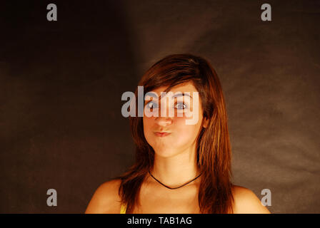 Giovane donna sbuffando sue guancie. Foto Stock